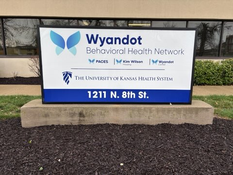 Photo of monument sign displaying logos of Wyandot Center, PACES, Kim Wilson Housing and the University of Kansas Health System