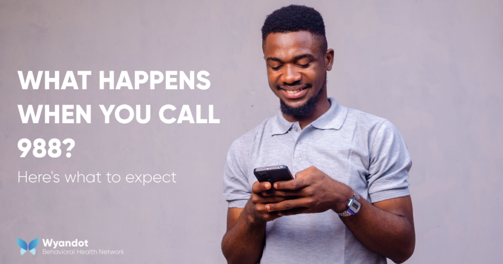 Person looking at a phone with the text "What Happens When You Call 988? Here's What to Expect." What happens when you call 988.